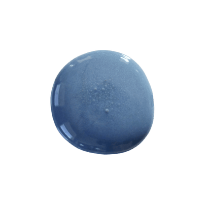 a drop of denim milk paint on a solid black background.