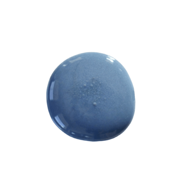 a drop of denim milk paint on a solid white background.