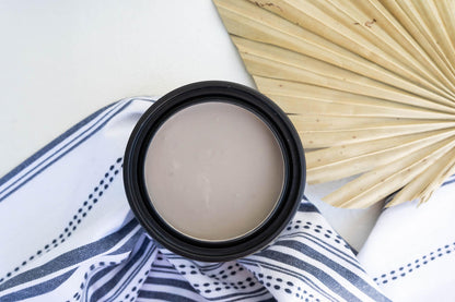 Desert Tan Terra Clay Paint, photographed from above on a white surface with a navy-and-white striped cloth and a dried palm leaf prop.