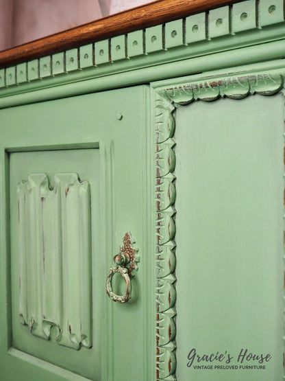 Vintage green cabinet with decorative details and a small handle, featuring 'Gracie's House' branding.