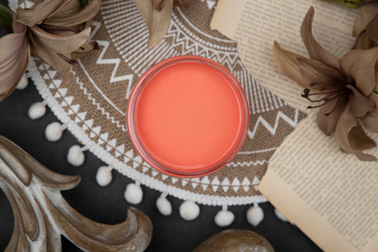 Coral-colored product on a decorative surface with flowers and patterns