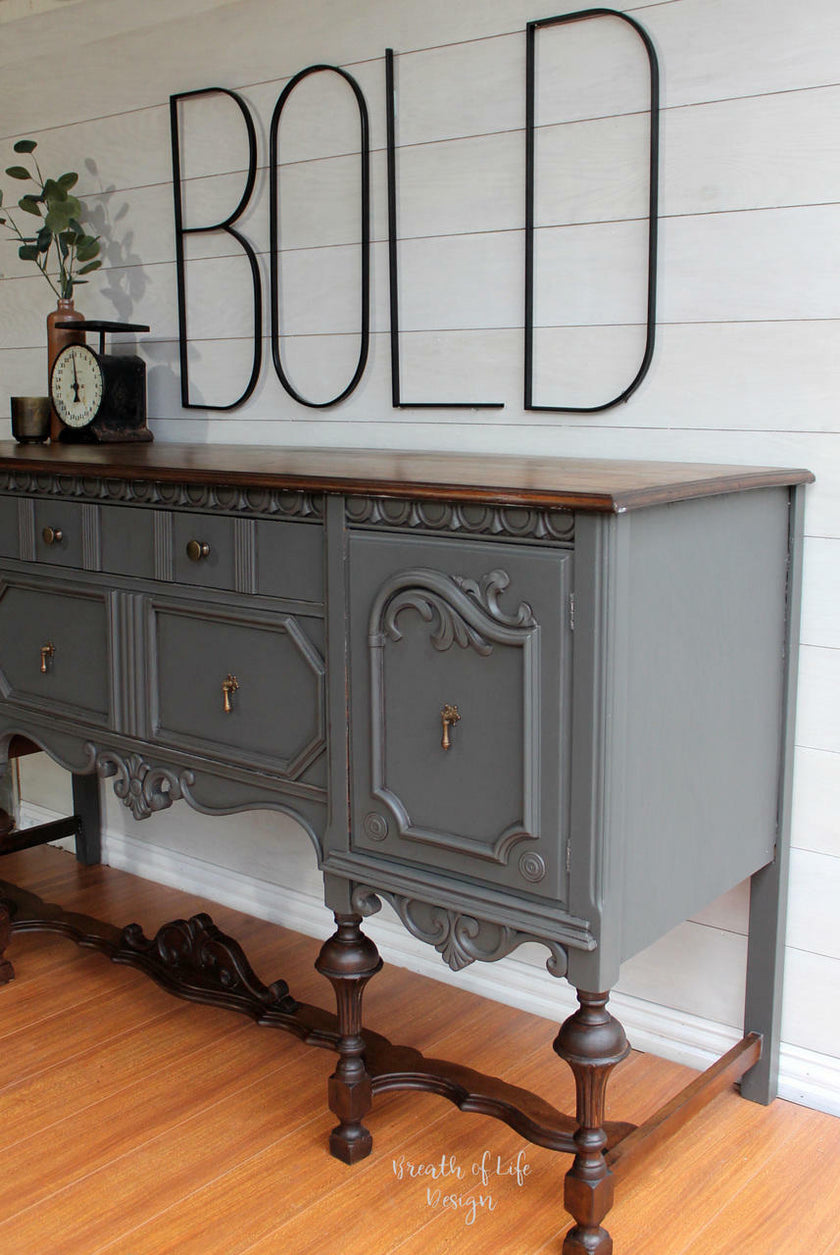 Gray sideboard with wooden top against a white wall with 'BOLD' text