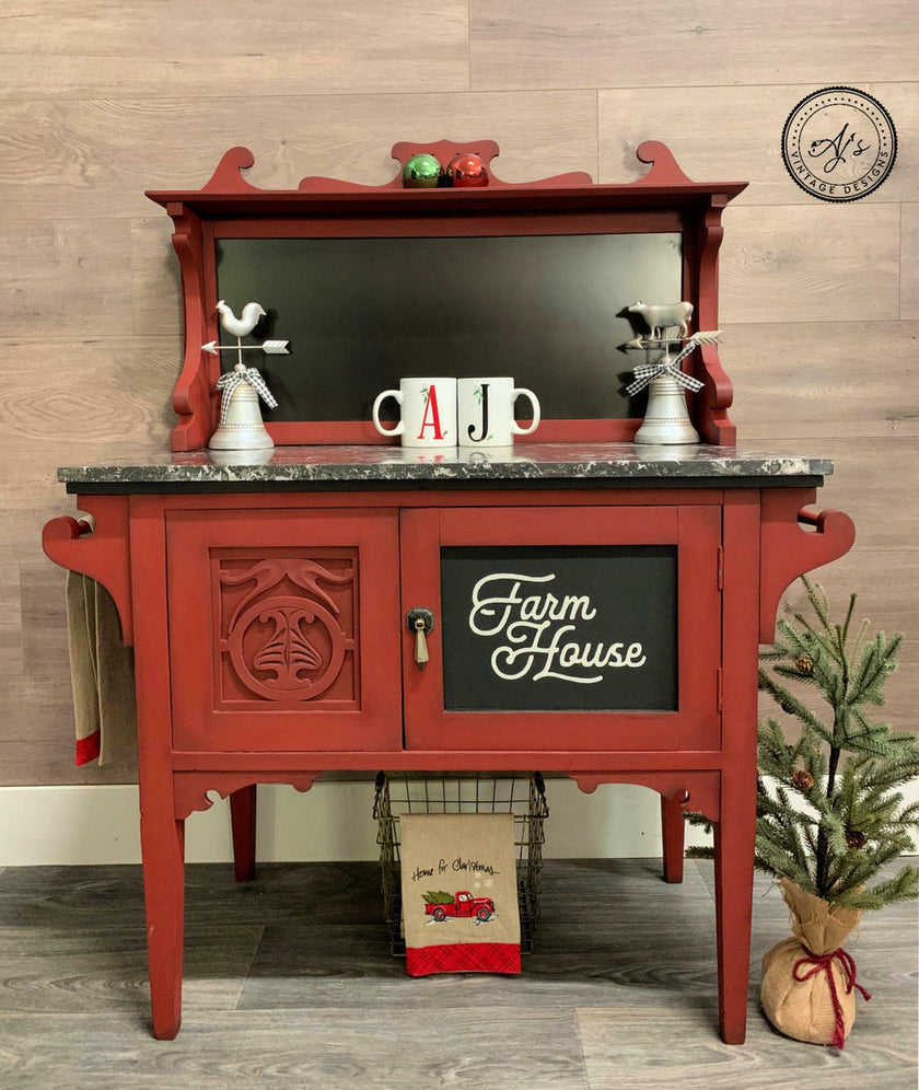 Red farmhouse-style cabinet with decorative items on a wooden floor.