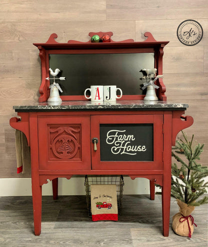 Red farmhouse-style cabinet with decorative items on a wooden floor.