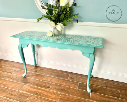 Turquoise table with floral arrangement against a light blue wall