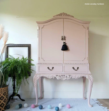 Pink ornate cabinet with decorative elements in a room setting