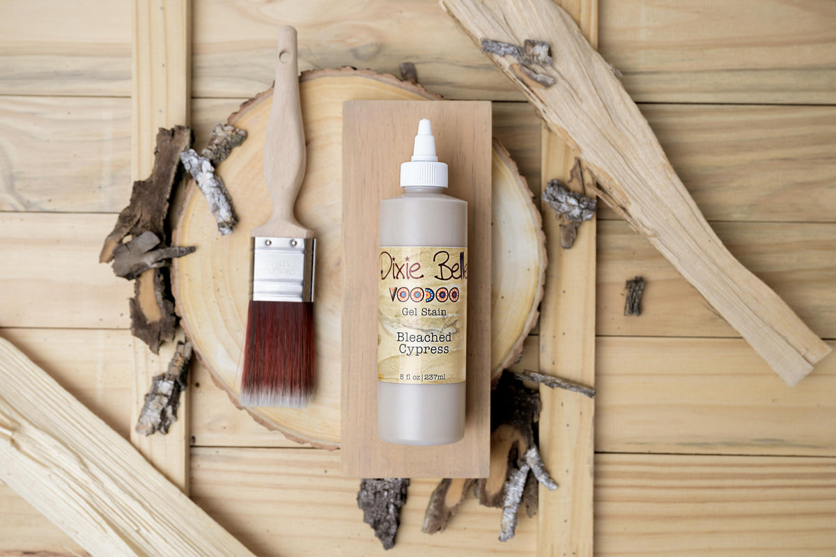 Bleached Cypress wood stain bottle with brush on a wooden background
