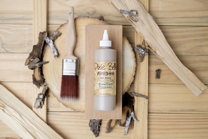 Bleached Cypress wood stain bottle with brush on a wooden background