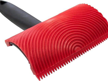 Red wood graining tool with black handle on a white background