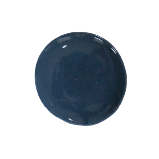 a drop of navy blues milk paint on a solid white background.