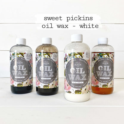 Four bottles of 'sweet pickings oil wax - white' on a white background
