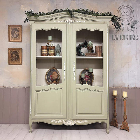 Vintage-style cabinet with decorative items against a rustic wall.