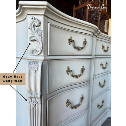 A close-up of an ornate white dresser with antique gold drawer pulls and carved decorative details. A text callout reads 'Gray Best Dang Wax' with arrows pointing to the painted wood finish, and a watermark 'Thereza Lee' appears in the top right.