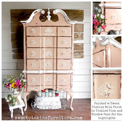 A vintage-style wooden cabinet or hutch painted in distressed pickled pink with white trim, shown in a home interior setting with flowers, a small side table, and shelving. The image includes close-up inset panels on the right and text reading 'Painted w/Sweet Pickins Milk Paint in Pickled Pink and Window Pane for the highlights' plus 'sweetpickinsfurniture.