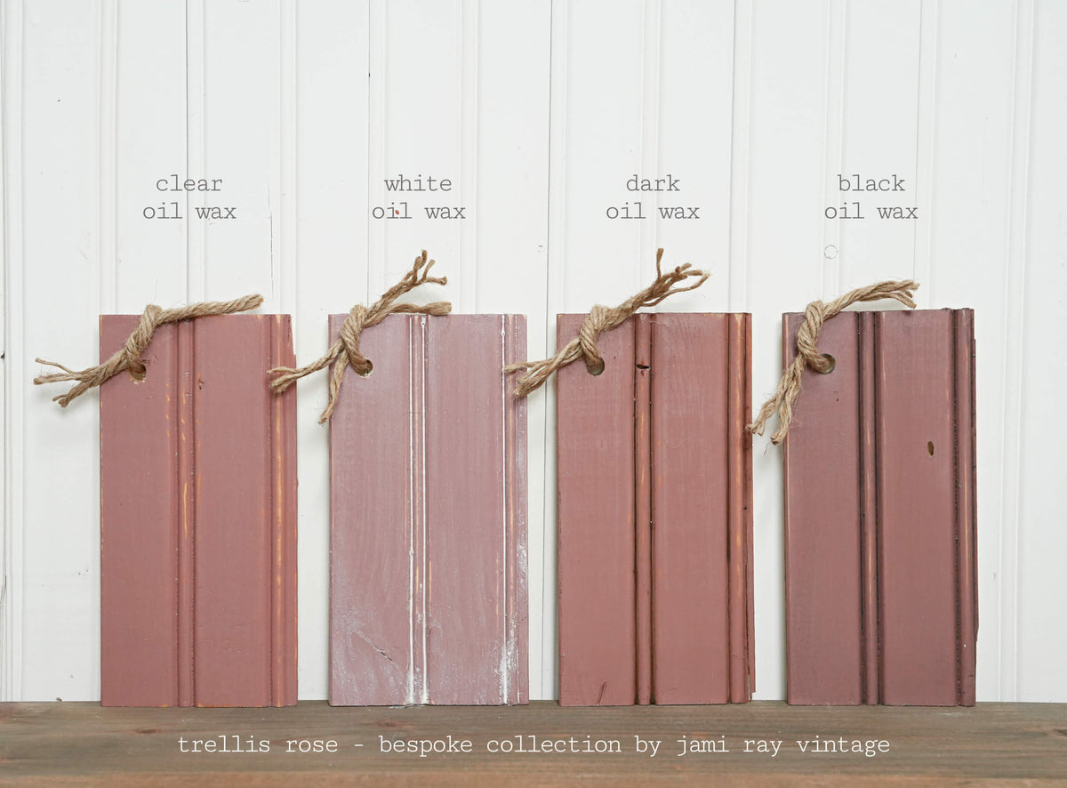 Four wooden planks with different oil wax finishes on a white background