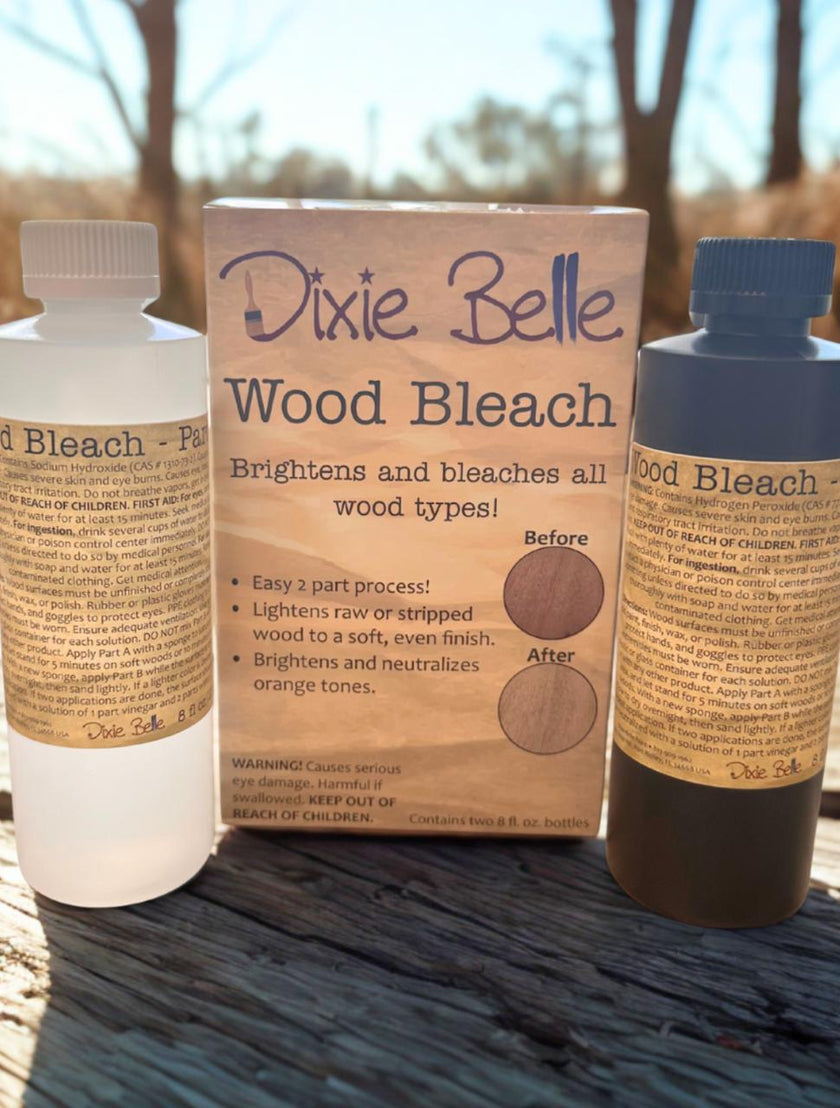 Dixie Belle Wood Bleach packaging with two bottles on a wooden surface outdoors.