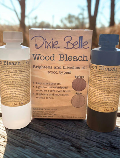 Dixie Belle Wood Bleach packaging with two bottles on a wooden surface outdoors.